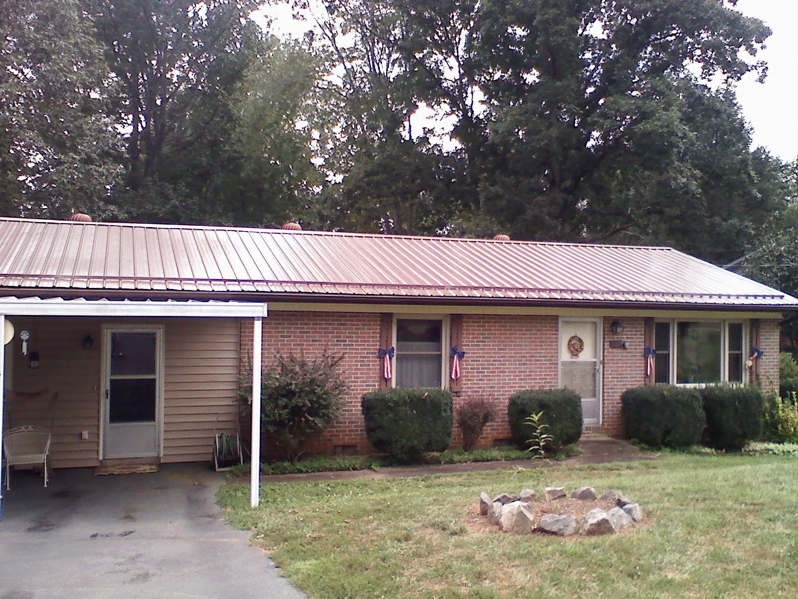 Bronze metal roof and carport on a brick ranch home — Roof Repair work by our crew in Bolton